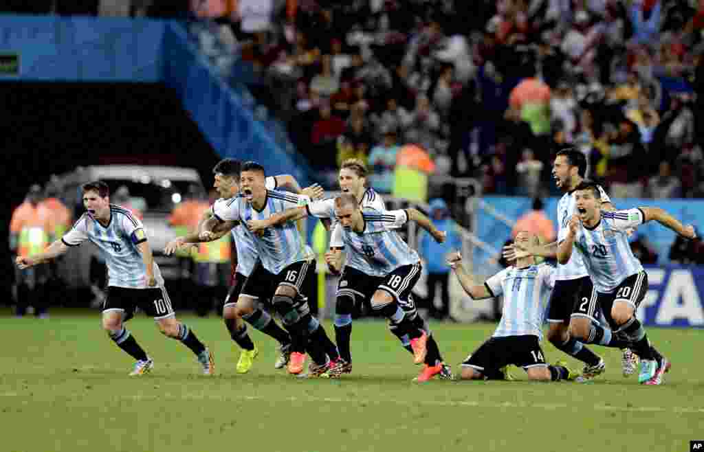 Argentine players react after Maxi Rodriguez scored the winning goal during a penalty shootout after extra time during the World Cup semifinal soccer match between the Netherlands and Argentina at Itaquerao Stadium in Sao Paulo Brazil, July 9, 2014.