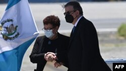 La ministra de Salud de Guatemala, María Amelia Flores saluda al canciller mexicano, Marcelo Ebrard, a su llegada a la Base Aérea de la Ciudad de Guatemala, el 24 de junio de 2021.