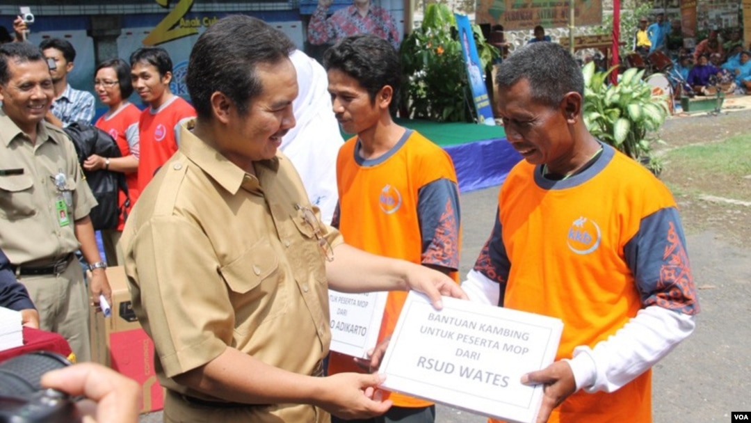 Petugas pemerintah kabupaten Kulonprogo, DI Yogyakarta, memberikan hadiah simbolis yang menyatakan hadiah kambing bagi mereka yang melakukan vasektomi. (VOA/Nurhadi Sucahyo)