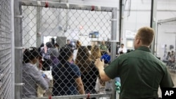 Un agente de aduanas y protección fronteriza de EE.UU. observa a migrantes detenidos por ingresar ilegalmente al país, en una instalación del gobierno en McAllen, Texas, el domingo 17 de junio de 2018. Foto proporcionada por la agencia de Aduanas y Protección Fronteriza, en el sector del Río Grande Valley vía AP.