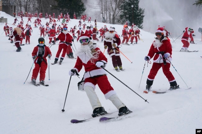 FILE - Skiers dressed in Santa Claus outfits hit the slopes for charity at the Sunday River Ski Resort, Sunday, Dec. 11, 2022, in Newry, Maine. (AP Photo/Robert F. Bukaty)