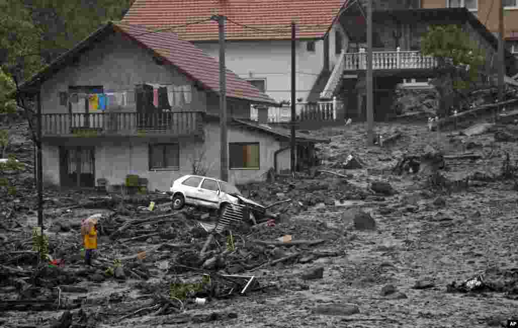 Người đàn ông Bosnia nhìn cảnh hoang tàn sau trận đất chuồi do lũ lụt gây ra trong một huyện cách thủ đô Sarajevo của Bosnia và Herzegovina 120 km về hướng bắc.