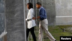 U.S. President Barack Obama and first lady Michelle Obama tour the jail where Nelson Mandela was imprisoned on Robben Island, near Cape Town, June 30, 2013. 