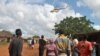 Residents look at a police helicopter patrolling near the closed house, where Italian volunteer for the Italian charity Africa Milele lived before she was seized, in Chakama trading centre of Magarini, Kilifi County, Kenya Nov. 21, 2018. 