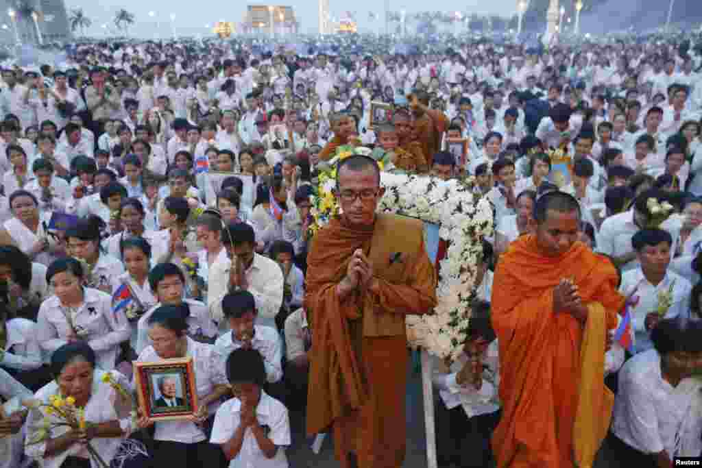 Thousands of mourners pray at the gates of the Royal Palace after the coffin of former king Norodom Sihanouk entered in Phnom Penh October 17, 2012. 