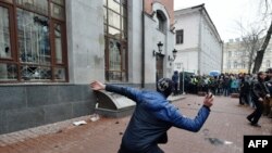 Des militants de plusieurs partis ultranationalistes ukrainiens lancent des pierres et des œufs aux fenêtres du bâtiment Rossotrudnichestvo (Centre russe des sciences et de la culture), à Kiev, le 18 février 2018.