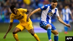 Le milieu de terrain ghanéen de l'Atletico Madrid, Thomas Partey, à gauche, en duel avec Lucas Perez, attaquant espagnol du Deportivo La Coruna, lors du match de foot du RC Espagnol contre le Club Atletico de Madrid, le 4 novembre 2017.