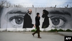 Un mur peint montrant Zalmay Khalilzad (g) le représentant spécial des États-Unis pour la réconciliation en Afghanistan et le cofondateur des talibans, Mullah Abdul Ghani Baradar, à Kaboul, le 5 avril 2020.