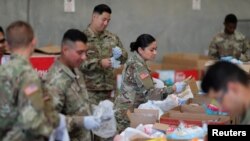 Pasukan Garda Nasional California menyiapkan paket bantuan makanan untuk bantuan makanan para lansia di tengah wabah virus corona, di Indio, California, 26 Maret 2020. (Foto: Reuters)