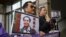 FILE - Pro-democracy Civic Party protesters carry portraits of missing booksellers Lee Bo, left, and Gui Minhai outside the Chinese Liaison Office in Hong Kong, Jan. 19, 2016. Lee Bo returned to his home on March 24, 2016.