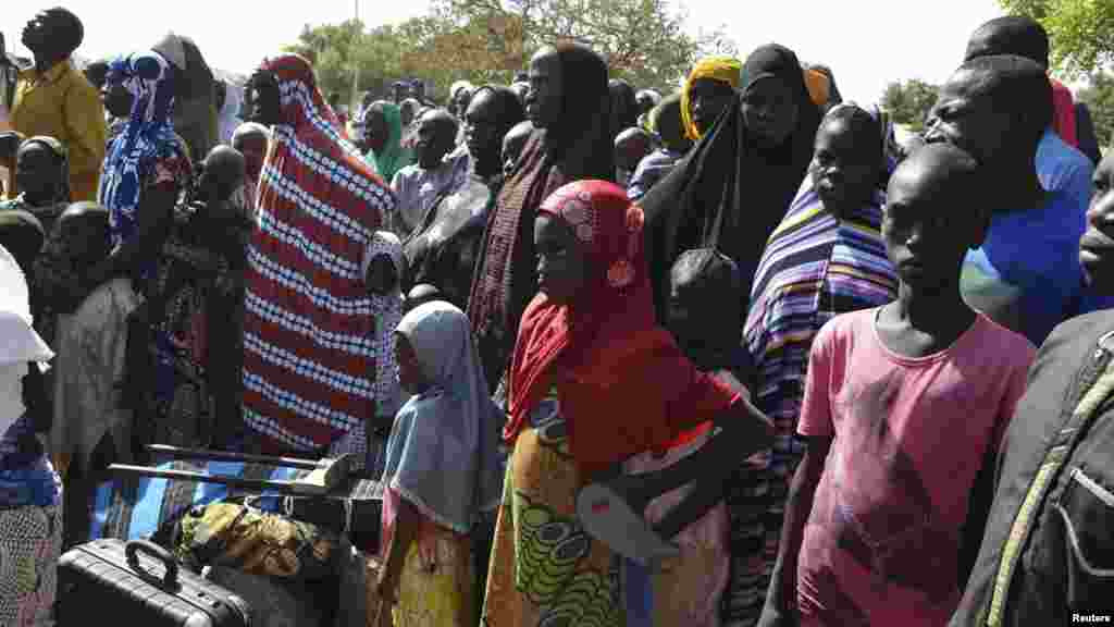 Wasu mutane kennan daga Gwoza, jihar Borno, da tashe-tashen hankula ya raba da gidajensu, suna taro a sansanin ‘yan gudun hijira a lokacin da gwamnan jihar Borno Kashim Shettima (babu hotonshi) a garin Mararaba Madagali, jihar Adamawa. Fabrairu 18, 2014. 