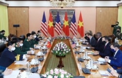 U.S. Defense Secretary Lloyd Austin, third from right, and Vietnamese Defense Minister Phan Van Giang, third from left, hold a meeting in Hanoi, Vietnam, July 29, 2021.