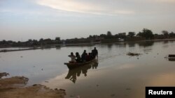 Residents navigate a boat across floodwater after heavy rains in Ndjamena, Chad September 2, 2022. Thousands battle floods after Chad's heaviest rains in over 30 years.