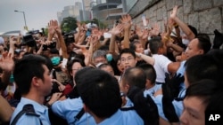 Student protesters resist during change of shift for local police but backed down after being reassured they could reoccupy the pavement outside the government compound’s gate in Hong Kong, Oct. 2, 2014.