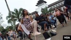 Seratusan peserta IWD Bandung melakukan tari "One Billion Rising" yang menyuarakan perlawanan terhadap kekerasan seksual, Bandung, Minggu, 8 Maret 2020. (Foto: Rio Tuasikal/VOA)