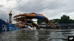 Athletes compete in the swimming race in the Seine during the women's individual triathlon at the 2024 Summer Olympics, July 31, 2024 in Paris, France.