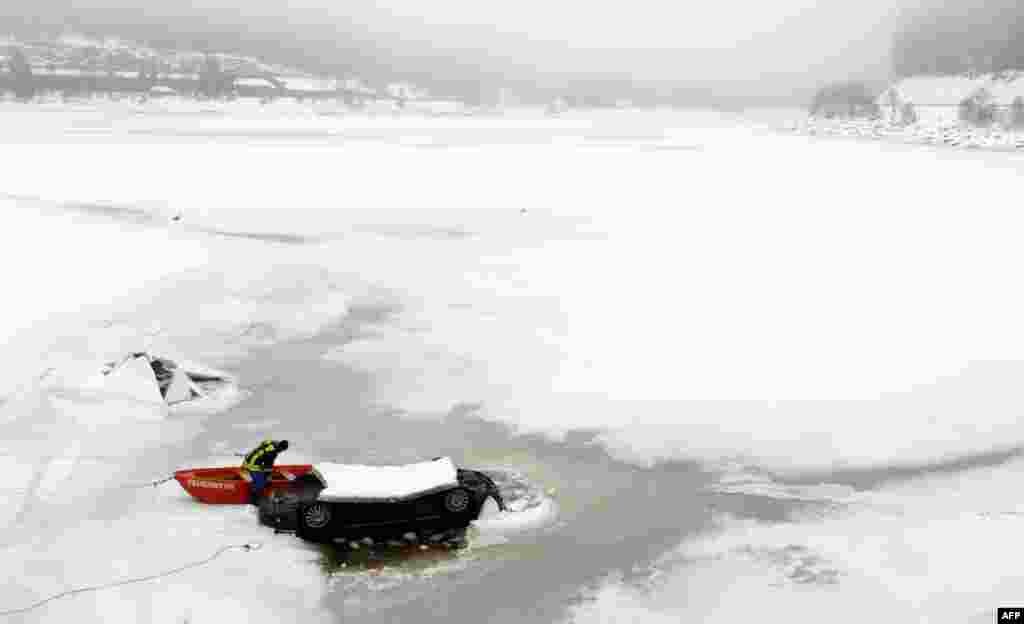 A firefighter rescues a car stuck in the frozen Schluchsee lake in the Black Forest region, southern Germany. According to the police, the car was empty. 