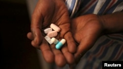 Nine-year-old Tumelo shows off antiretroviral (ARV) pills before taking his medication at Nkosi's Haven, south of Johannesburg, Nov. 28, 2014. Nkosi's Haven provides residential care for destitute HIV-positive mothers and their children, whether HIV-posit