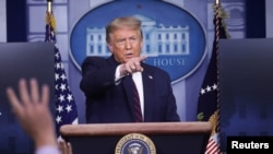 President Donald Trump points to a reporter for a question during a news briefing at the White House in Washington, July 21, 2020.