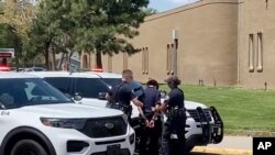 In this image from taken from video courtesy of Ryan Laughlin/KOB 4 TV, Albuquerque, NM, police search a student after a shooting at Washington Middle School which left one student dead and another in custody, police said Friday, Aug. 13, 2021.