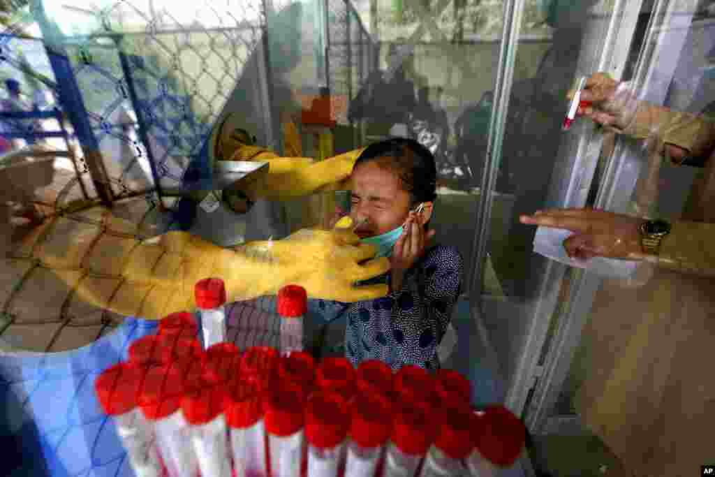 A young girl reacts while being tested for COVID-19 at a hospital in Karachi, Pakistan.