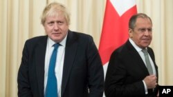 British Foreign Secretary Boris Johnson, left, and Russian Foreign Minister Sergey Lavrov arrive for a news conference following their talks in Moscow, Russia, Dec. 22, 2017.