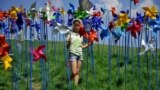 A girl spins pinwheels at a peace park, which was built to deliver the peace between North and South Korea, near the border village of Panmunjom in Paju, north of Seoul, South Korea.