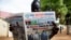 A resident reads a daily newspaper on April 27, 2016 reporting on the arrival and swearing-in of rebel leader Riek Machar in Juba, South Sudan, a day after his return. 