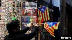 Un commerçant affiche des drapeaux séparatistes catalans "Estelada" dans un magasin de Barcelone, 22 décembre 2017. 