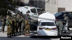 Pasukan Israel berjaga di dekat lokasi penembakan di Hebron di Tepi Barat yang diduduki Israel, 1 Februari 2024. (Foto: REUTERS/Mussa Qawasma)