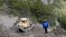 French Gendarme Bruno Hermignies stands by a bulldozer clearing a path to the crash site of the Germanwings Airbus A320 in the mountains, near Seyne-les-Alpes, French Alps, March 30, 2015. 