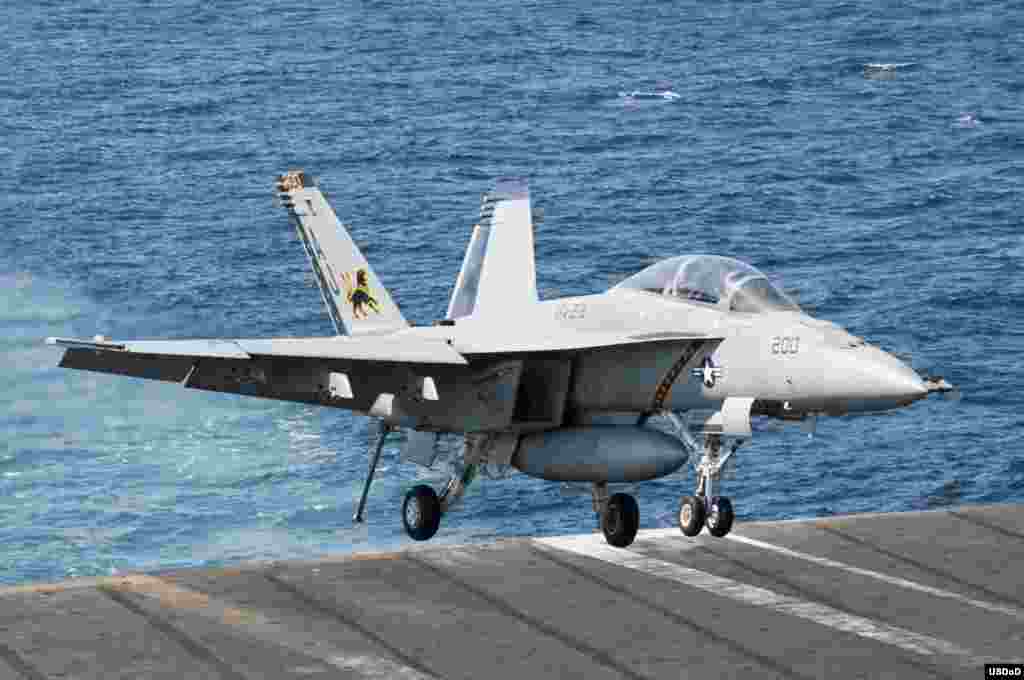 An F/A-18F Super Hornet attached to the Fighting Black Lions of Strike Fighter Squadron (VFA) 213 lands aboard the aircraft carrier USS George H.W. Bush (CVN 77) after conducting strike missions against ISIL targets. George H.W. Bush is supporting maritime security operations and theater security cooperation efforts in the U.S. 5th Fleet area of responsibility, Arabian Gulf, Sept. 23, 2014. (U.S. Navy photo by Mass Communication Specialist 3rd Class Brian Stephens/Released) 