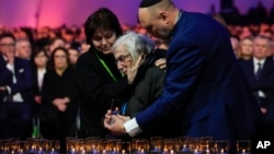 A holocaust survivor gets a hug after placing a lilt candle at the Auschwitz-Birkenau former Nazi German concentration and extermination camp, during a ceremony marking the 80th anniversary of its liberation, in Oswiecim, Poland, Jan. 27. 2025.