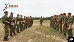 Na fotografiji sa video snimka koje je objavilo Ministarstvo odbrane Belorusije na Voen TV u petak, 14. jula 2023, vidi se instruktore iz grupe Vagner kako razgovara sa beloruskim vojnicima za vreme obuke jugoistsočno od Minska. 