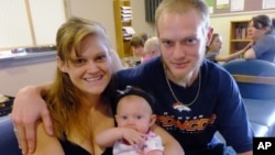 New parents Garrett Goudeseune, 25, Laura Fritz, 27, left, with their daughter Adalade Goudeseune, are at the Jefferson Action Center, an assistance center in the Denver. The couple has struggled to find work, now relying on government assistance to cover food and $650 rent for their family, July 16, 2012.