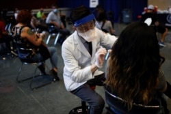 A person receives a dose of the Johnson & Johnson coronavirus vaccine at a vaccination center in Chinatown, in Chicago, Illinois, April 6, 2021.