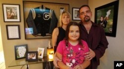 Gary and Johanna Cuccia with their daughter Alisa at their home in Pennsylvania in 2010. Behind them are photos of another daughter, Demi, who was stabbed to death by her boyfriend on her 16th birthday after breaking up with him.