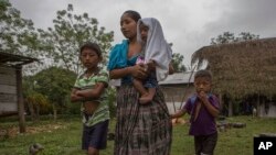 Claudia Maquin (27 años), camina junto a sus hijos Abdel, (9 años), Ángela (6 meses) en brazos, y Elvis Caal Maquin (5 años) en Raxruha, Guatemala. Su hija de 7 años, Jakelin murió en un hospital de Texas dos días después de ser detenida por agentes fronterizos en Nuevo México.