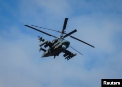 A Russian Ka-52 "Alligator" attack helicopter flies over the settlement of Panteleimonivka in the Donetsk region, Russian-controlled Ukraine, Feb. 17, 2024.