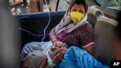 A patient breathes with the help of oxygen provided by a gurdwara, a Sikh place of worship, inside a car in New Delhi, India, April 24, 2021. India’s medical oxygen shortage has become dire.