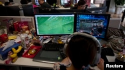 Seorang karyawan menonton layar komputer yang menampilkan video game "Glorious Mission Online" di kantor pengembang game di Shanghai, 2 Agustus 2013. (Foto: Reuters)