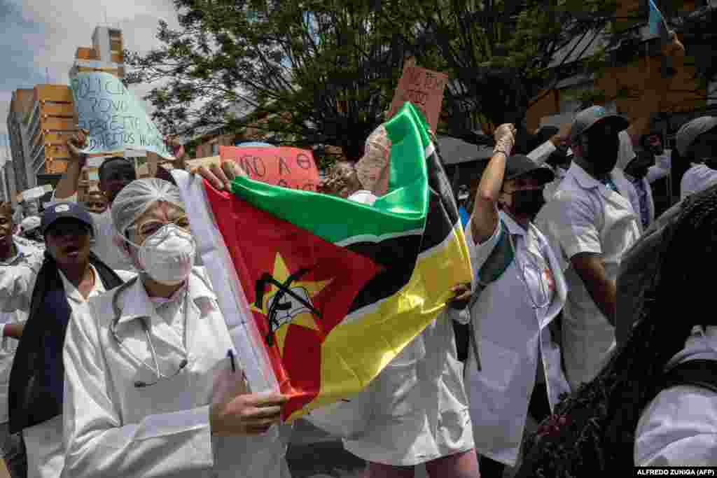 Membros da comunidade médica moçambicana marcham com a bandeira de Moçambique, em Maputo, contra a violação dos direitos humanos 