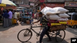 FILE - A rickshaw puller transports a load at a wholesale market in Hyderabad, India, Thursday, Feb. 1, 2024. India's policymakers are trying to head off a sharp slowdown as global economic conditions worsen.