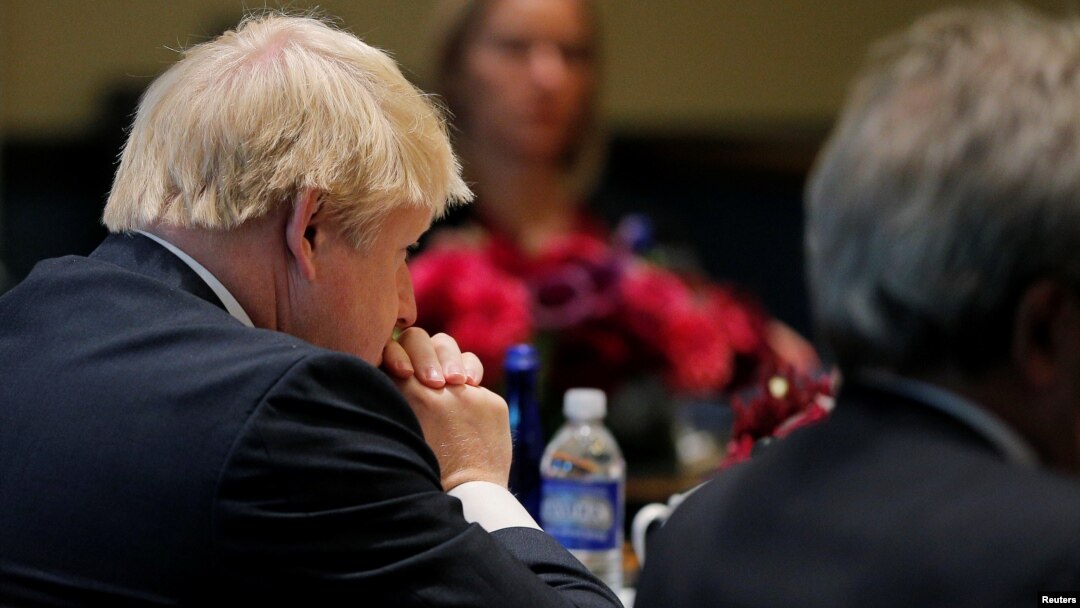 FILE - United Kingdom Foreign Secretary Boris Johnson (L) and European Union High Representative Federica Mogherini (rear) listen as United States Secretary of State John Kerry speaks during a meeting of foreign ministers from Germany, the UK, France, Ita