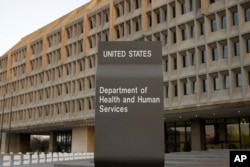 FILE - The Department of Health and Human Services building is seen in the evening in Washington.