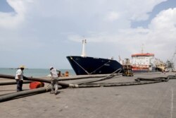 FILE - Workers prepare to unload a fuel shipment from an oil tanker at the port of Hodeida, Yemen, Oct. 17, 2019.