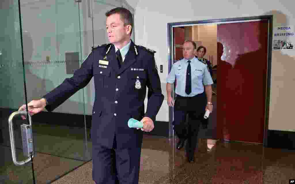 Australian Federal Police Acting Commissioner Andrew Colvin, left, leaves a press conference after describing how 800 federal and state police officers raided more than two dozen properties as part of the anti-terror operation in Sydney, Sept. 18, 2014. 