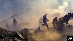 FILE - Indian artillery guns are engulfed in smoke in Dras, 155 kilometers (96 miles) north of Srinagar, India, as Indian troops fight Pakistani intruders in the disputed Kashmir, July 10, 1999.