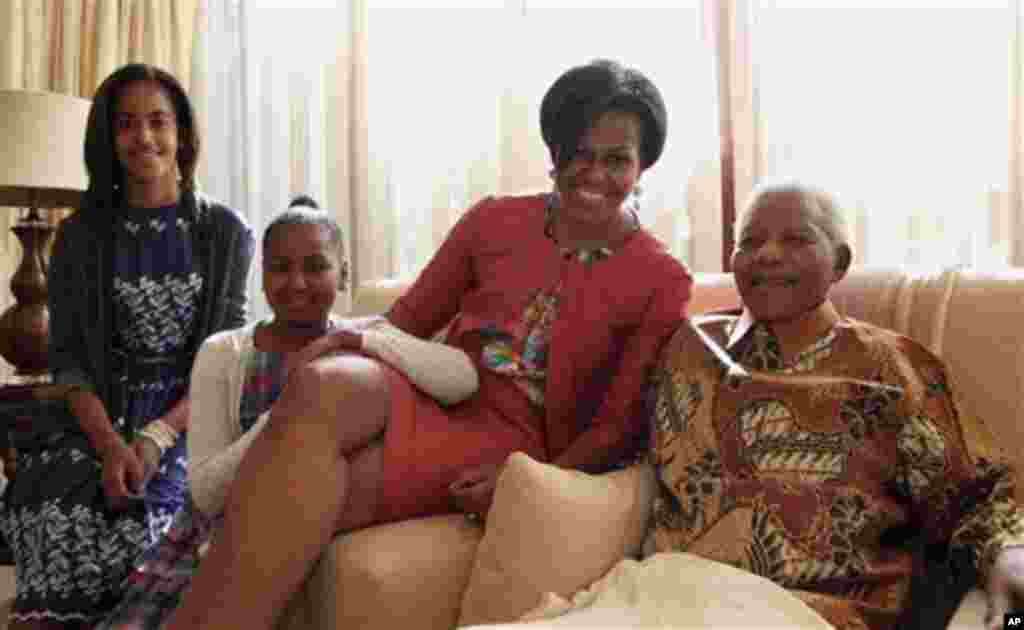 Primeira Dama, Michele Obama, com Nelson Mandela durante a sua visita à África do Sul, em Junho de 2011. As filhas do casal Obama, Malia (esq) e Sasha, acompanharam a mãe.
