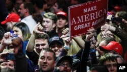 FILE - attendees cheer at the media riser at the encouragement of President-elect Donald Trump while he speaks during the first stop of his post-election tour in Cincinnati. 